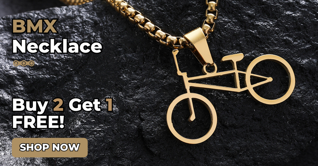 Gold BMX necklace on a dark stone background with promotional text.