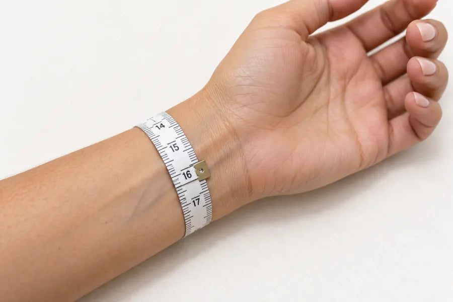 A soft measuring tape wrapped snugly around the wrist above the wrist bone.